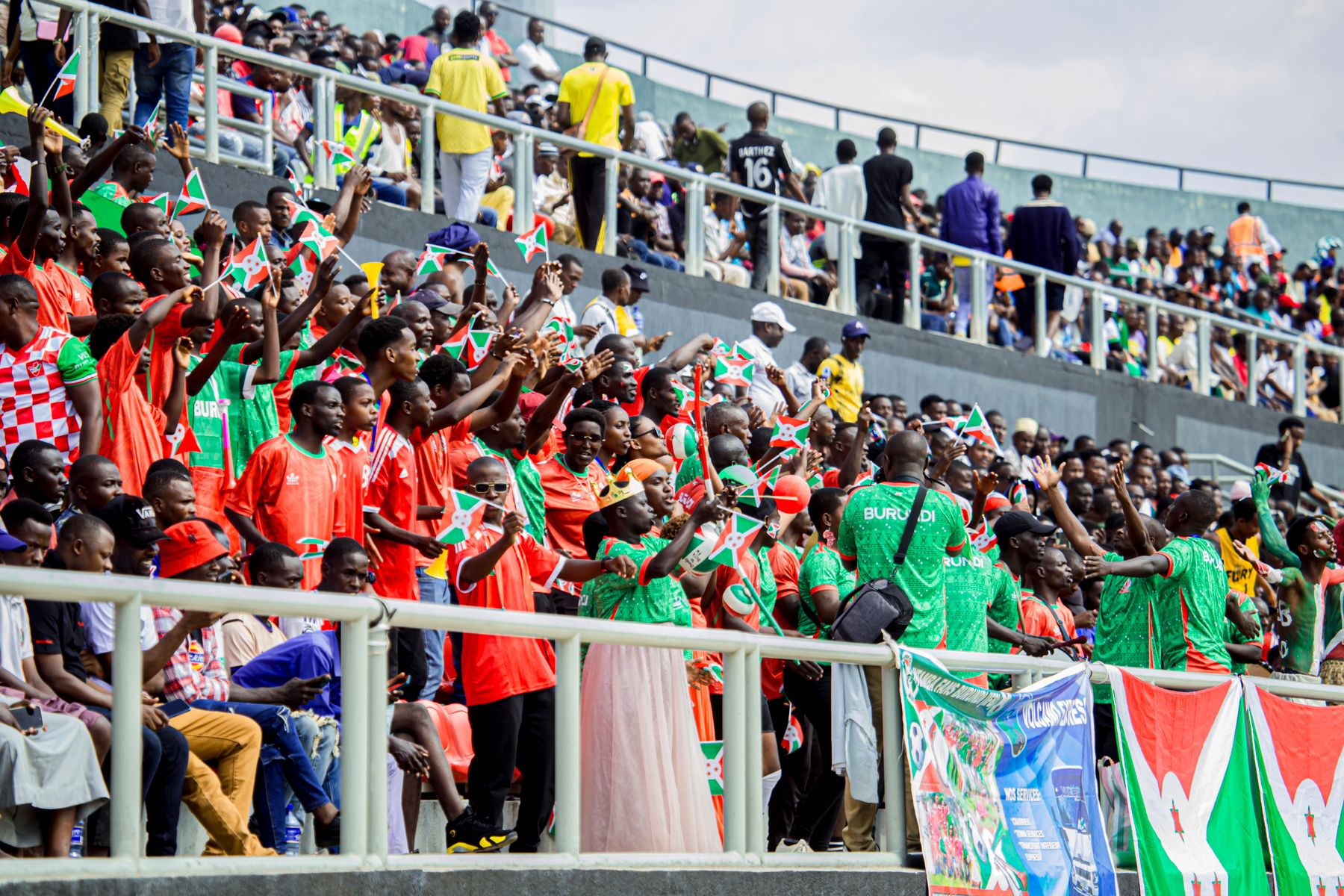 East African football supporters celebrating together in a stadium ahead of AFCON 2027